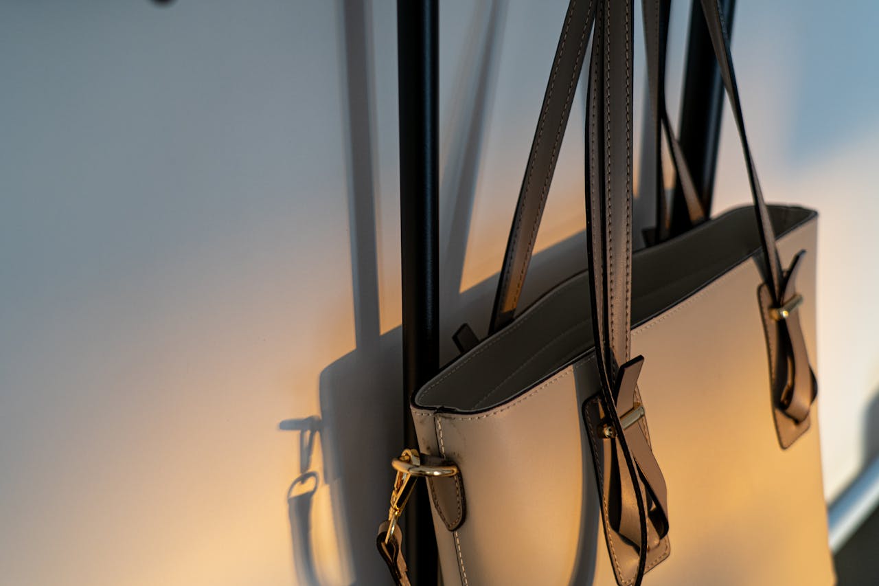 Home High-quality leather handbag elegantly hanging on a wall with soft lighting.
